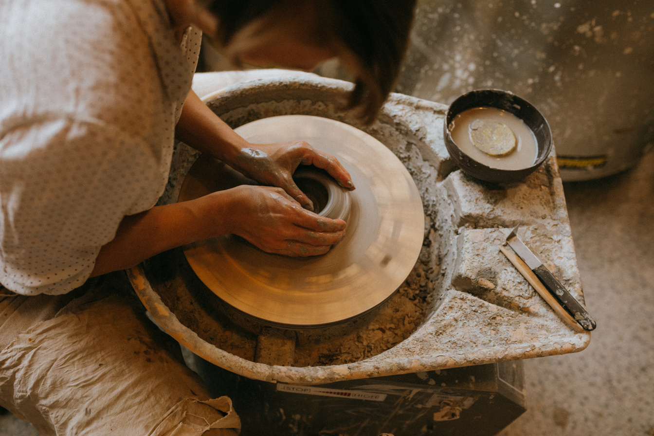 A Person Sculpting Clay on Pottery Wheel